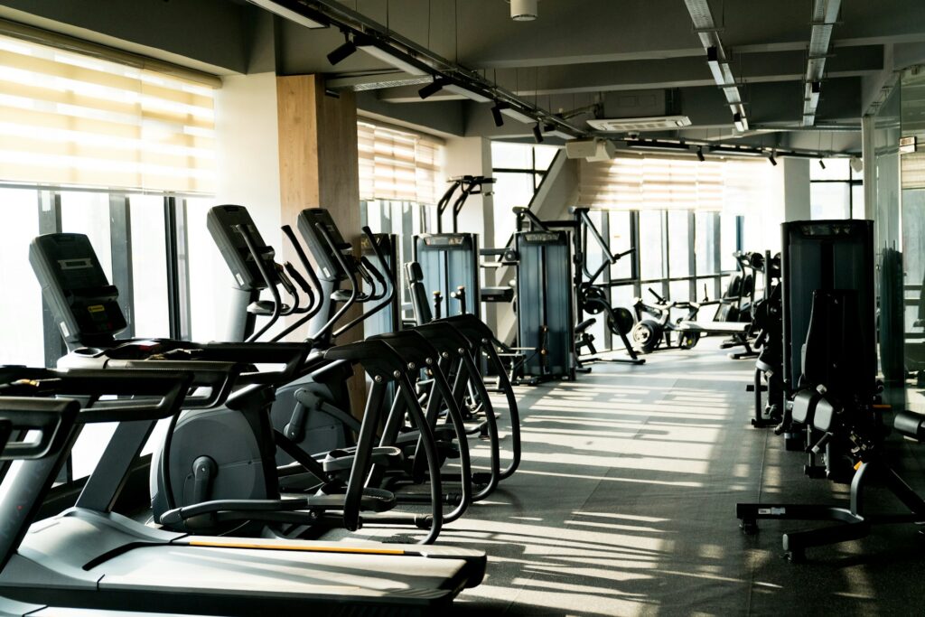 A row of treadmills and ellipticals in a commercial gym