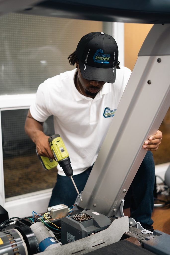 An FMT technician works on a treadmill. Service brands like this excel in Florida, where gyms abound and overhead is low.